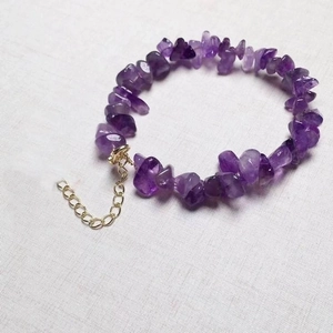Macro shot of natural irregular purple amethyst stone beads with gold extension chain
