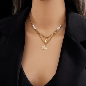 Double-layered gold titanium necklace featuring small pearls and butterfly pendants on a model