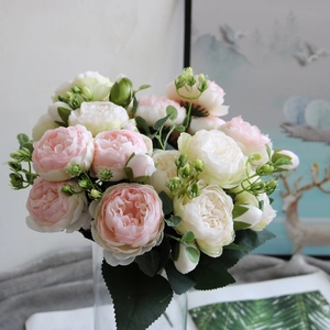 Detailed view of pink and white faux peony bouquet in a transparent glass vase for decor
