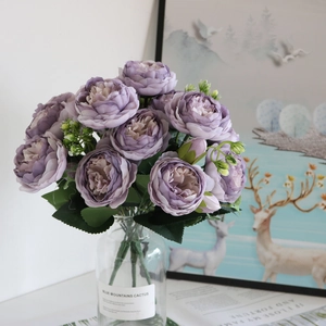 Detail of purple artificial peony bouquet in glass vase for home interior decoration