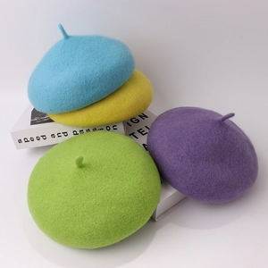 Berretti per bambini in lana azzurro, giallo, verde e viola su sfondo bianco