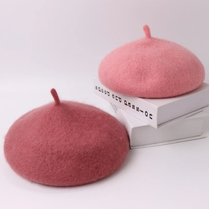 Classici baschi per bambini in feltro di lana rosa e malva su uno sfondo minimalista