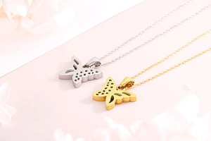 Close-up of hollow butterfly pendants in gold and silver finish with elegant link chain