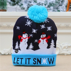 Detail of blue knitted Christmas hat with LED lights, snowman pattern and Let It Snow text