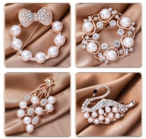 Macro detail of rose gold floral and swan brooches with pearls and sparkling rhinestones
