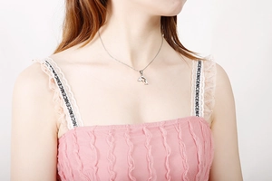 Silver dolphin pendant necklace worn by a model against a clean white background