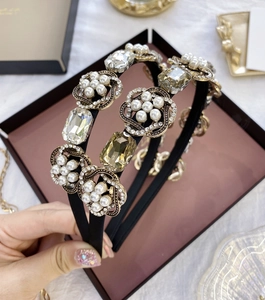 Détail d'un serre-tête baroque avec cristaux larges, perles et accents dorés élégants