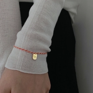 Red braided rope bracelet with golden Good Luck pendant charm for women