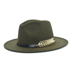 Detail of dark green wool fedora hat featuring a gold feather charm on a black band