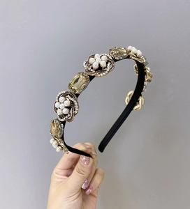Détail d'un serre-tête baroque avec cristaux jaunes et motifs de fleurs en perles sur métal