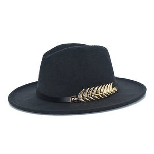 Close-up of black fedora wool hat featuring a classic band and gold leaf metal accessory