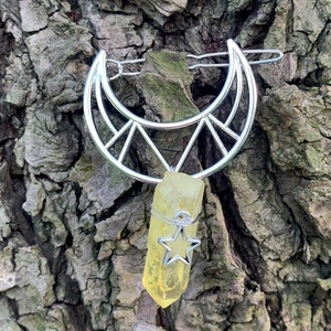 Detailed view of silver hollow moon hair clip with natural yellow crystal and star charm