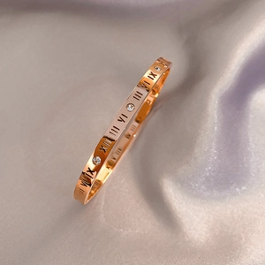 Eleganter roségoldener Armreif mit römischen Ziffern und funkelnden Kristallakzenten