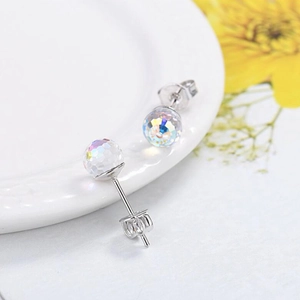Close-up of faceted crystal ball stud earrings with rainbow AB color coating and silver posts