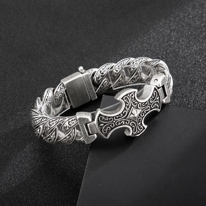 Macro shot of silver retro bracelet with embossed floral patterns and thick chain links