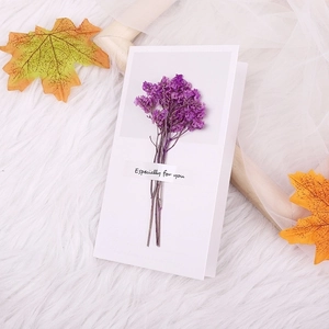 Macro shot of Especially for you greeting card with purple dried flowers on white fur