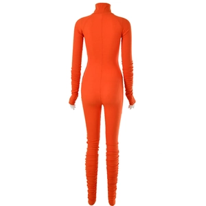 Rear view detail of orange high neck jumpsuit showing ruched cuffs and fitted silhouette