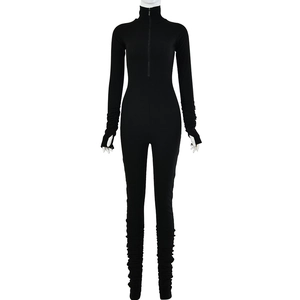 Detail view of black long sleeve jumpsuit featuring zip neck, ruching and thumbhole cuffs