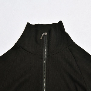Detail of black ribbed knit bodysuit showing the stand-up collar and metal zipper closure