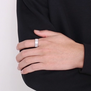 Macro shot of silver brushed stainless steel square ring worn on a model's finger