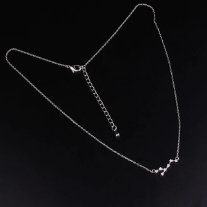 Silver constellation pendant necklace with sparkling cubic zirconia on a sleek black backdrop