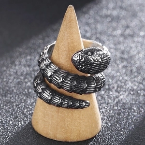 Vintage punk silver snake ring with scale texture on a wooden cone display