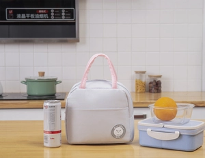 Detailed close-up of a light grey thermal bento bag with pink handles in a kitchen setting