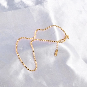 Detail of 18K gold-plated bead necklace featuring lobster clasp and extension chain