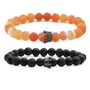 Detail of 8mm lava rock and orange stone beaded bracelets with black crown charms