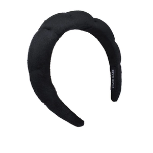Detailed view of handmade black velvet braided headband with soft texture and inner label