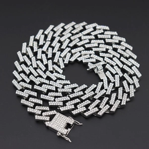 Detailed view of silver Cuban link chain with pave setting rhinestones on black background