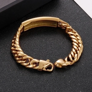 Gold stainless steel link bracelet with rectangular curved plate on black textured surface