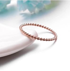 Macro detail of rose gold twisted rope ring showing the fine metallic texture
