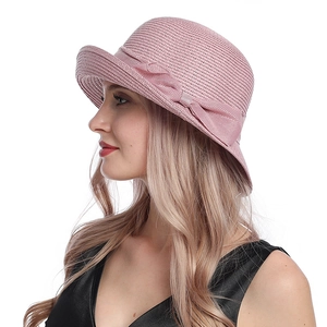 Detail of pink woven sun hat with bow decoration on a model side view