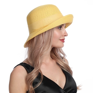 Detail of yellow straw sun hat featuring a side view of the elegant decorative ribbon