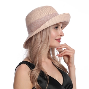 Close-up of lightweight light khaki straw hat featuring elegant matching ribbon detail