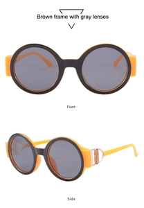 Macro detail of round orange frame sunglasses with dark gray lenses and metal D-shape temple