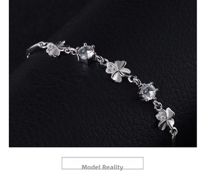 Detailed close-up of s925 silver four-leaf clover bracelet with zircon on black leather