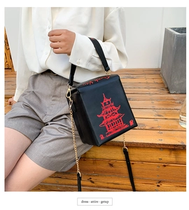 Detail of creative takeout box crossbody bag with red tower print and chain strap