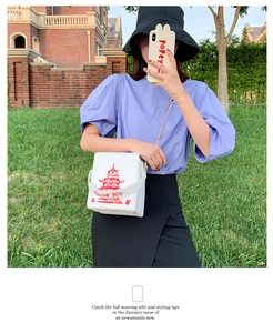 Close-up of Chinese takeout box crossbody bag with red tower print and chain strap