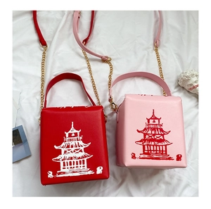 Detail of red and pink square crossbody bags with Chinese pagoda print and chain straps