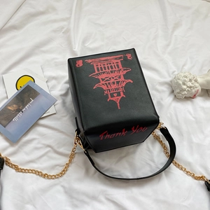 Detail of creative take-out box handbag with red tower print and gold chain strap