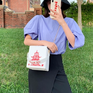Chic white crossbody bag with red Chinese pagoda print and gold chain strap detail