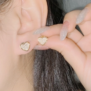 Sparkling heart-shaped 18k gold earrings with micro-pave cubic zirconia on ear