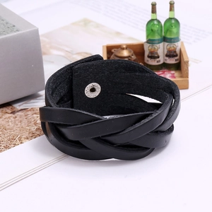 Detailed close-up of wide braided black genuine leather bracelet with snap closure