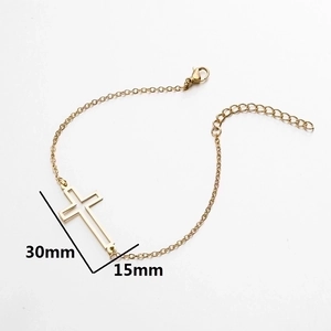 Minimalist gold cross charm chain bracelet with lobster clasp on white background