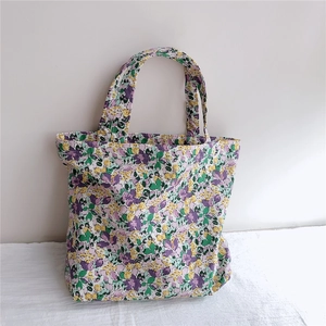 Close-up of floral cotton tote bag with purple and yellow patterns and dual handles