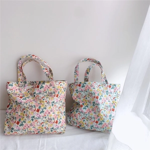 Detail of floral cotton tote bags with soft pastel flower patterns and handles