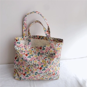 Close-up of floral canvas tote bag featuring pink and yellow blossoms on durable fabric