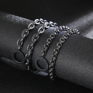 Collane in metallo nero stile punk con catena a maglie piatte e texture rotonde su fondo scuro